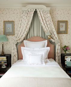 a bed with white sheets and pillows in a bedroom next to two lamps on nightstands