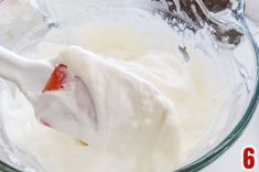 a bowl filled with whipped cream and strawberries