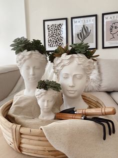 three white ceramic head sculptures in a basket