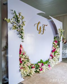 a white backdrop with flowers and the letter f is displayed on it's side