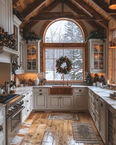 a kitchen decorated for christmas with wreaths on the window sill and wooden floors