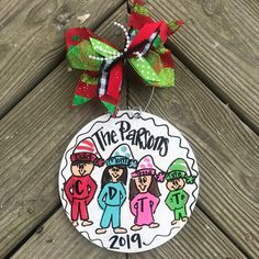 a christmas ornament hanging on the side of a wooden fence with a ribbon