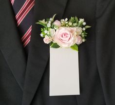 a man wearing a suit and tie holding a card with flowers on it