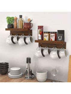 two wooden shelves holding pots and pans on top of a kitchen counter next to other dishes