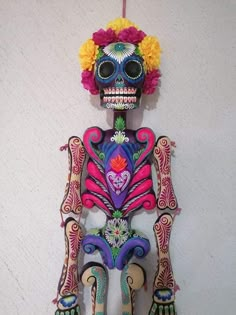 a colorful skeleton hanging from the side of a wall