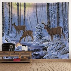 two deer are standing in front of a snowy forest wall hanging on a white wall