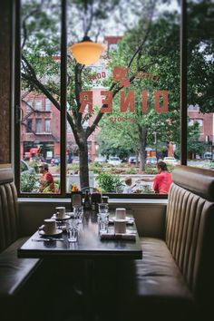 a restaurant with tables and chairs in front of large windows that look out onto the street