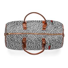 a black and white duffel bag with brown handles on the front, featuring an intricate pattern