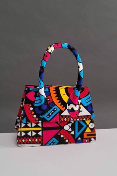 Turn heads with our cute and unique African Print mini bag . This fashionable and easy to carry Afrocentric handbag is perfect for any casual or formal occasion. Pair it up with a solid color outfit to elevate your look! Description: Afrocentric handmade bag with metal chain (chain about 20in) Can be worn as a crossbody bag Made with African wax fabric also known as Ankara Interior is a black compartment Lined with cloth Snap closure Easy to carry and versatile (from casual to formal) Perfect gi Hand Painted Bags Ideas, Nigerian Clothes, Hand Bags Ideas, Painted Handbag, Ankara Bags, Quirky Prints, African Bag, Statement Handbag, Bags Ideas