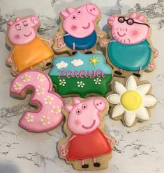 decorated cookies are arranged in the shape of peppa pig's numbers and flowers