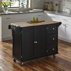 a kitchen island with two pears on it in the middle of a wooden floor