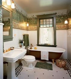 a bathroom with two sinks and a bathtub next to a toilet under a window