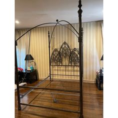 an iron bed frame in the middle of a room