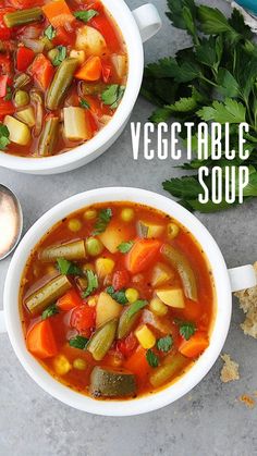 two bowls of vegetable soup on a table with bread and parsley next to it