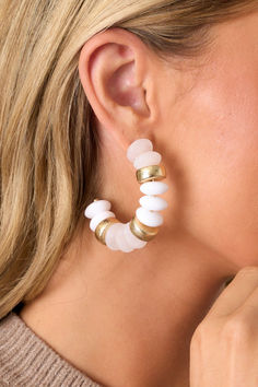 Elevate your style with our Bell Bottom Blues White Beaded Hoop Earrings. With their intricate bead detailing, these earrings are the perfect statement piece for any outfit. Add a touch of bohemian flair and effortlessly elevate your look with these versatile and stylish earrings. These beaded earrings feature gold hardware, white and gold flat beads with accent gold beads, an incomplete hoop and secure back postings.  Earrings measure 1" in Diameter  Lead & Cadmium Compliant Manufactured in China White Beaded Earrings, Flat Beads, Stylish Earrings, Gold Flats, Stylish Earring, Beaded Hoop Earrings, Bell Bottom, Merlot, Black Flats