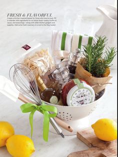 a white basket filled with lots of food next to lemons and other kitchen items