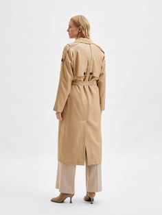 This beige trench coat is designed with a double-breasted closure and side pockets for a stylish and practical look. It has raglan sleeves and a reverse collar for a modern and sophisticated look. It is made from a high quality piqué fabric which makes it durable and comfortable to wear.
 Normal/large size.
 This coat is fully lined with 100% recycled polyester fabric , making it even more sustainable and environmentally friendly. Additionally, 52% of the composition of this coat is TENCEL™ Lyocell , a high-quality cellulose fiber made from wood pulp from sustainably managed forests.
 This makes this coat a sustainable choice for those looking for high-quality, environmentally friendly products. You can wear it on any occasion and feel comfortable and elegant at the same time. Longline Trench Coat, Beige Trench Coat, Coat For Women, Double Breasted Trench Coat, Trench Coats Women, Overall Dress, Trench Coats, Fashion Labels, Tie Belt