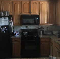 a kitchen with wooden cabinets and black appliances