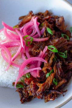 a white plate topped with meat and rice