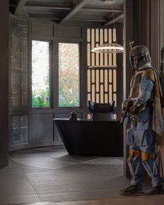 a man dressed as boba fett standing next to a desk in a room