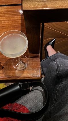 a person sitting on a chair with their feet up next to a glass of wine