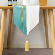 a white and blue table runner with tassels hanging from it