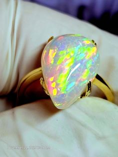 14k solid gold ring, with a very colorful natural crystal opal, the light purple background sets the colors aflame. The stone is 11x15mm and 4.74cts. This stone was very hard to photograph, as you can see I used different backgrounds,  the pics with the white gloves seem to be the best, but still not a true depiction of this beautiful stone, not even close. Will tighten the prongs when the ring size is determined. Unique Yellow Gold Ethiopian Opal Ring, Iridescent Opal Ring As A Gift, Iridescent Opal Ring Perfect For Gifts, Iridescent Opal Ring Gift, Multicolor Opal Round Ring, Multicolor Opal Gemstone Ring, Multicolor Opal Ring Gift, White Ethiopian Opal Ring For Promise, White Ethiopian Opal Promise Ring