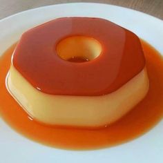 a dessert on a white plate with orange sauce and caramel in the top layer