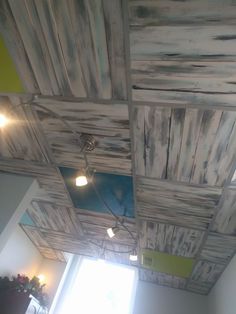 an unfinished ceiling with wooden planks and lights