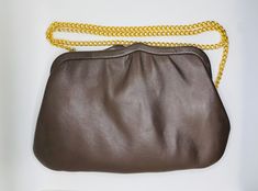 "Chic minimalist style convertible purse/clutch by Ande Circa late 1960's to early 1970's in a rich deep brown leather Fully lined with a contrast beach lined pocket Gold tone chain strap  6.5 \" height 10\" total length  Will accommodate mobile phone (iPhone) Approximately 18\" strap drop  Tension frame closure" Versatile Brown Clutch Affordable Price, Formal Brown Evening Bag With Chain Strap, Vintage Clutch With Chain Strap For Everyday Use, Brown Evening Bag With Chain Strap, Retro Brown Clutch For Evening, Brown Clutch With Chain Strap, Vintage Brown Bag With Chain Strap, Vintage Brown Everyday Clutch, Retro Brown Rectangular Clutch