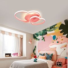 a bedroom decorated in pink and green with an artistic mural on the wall