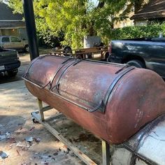 a large metal barrel sitting on top of a metal stand next to a black truck