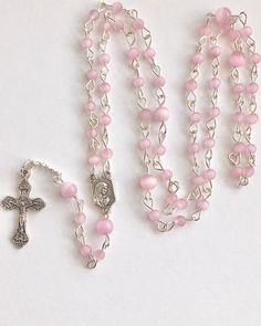 Handmade with small 4mm and 6mm pink cats eye beads and silver tone metal wire. I love the cats eye beads because of the ribbon of light that appears and follows the sun. Small Our Lady of Fatima medal and small crucifix. Comes with a gift pouch Pink Rosary, Mens Rosary, Pearl Rosary, Lady Of Fatima, Cats Eye, Eye Beads, Jewelry Lookbook, Gift Pouch, Pink Cat