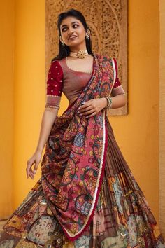 Brown attached cancan lehenga with ganesha and cows kalamkari hand painted patterns. Paired with padded maroon embroidered blouse and pink printed dupatta. - Aza Fashions Kalamkari Lehangas Designs, Chaniya Choli Dupatta Style, Blouse Designs Kalamkari, Kalamkari Half Saree Lehenga, Pattu Gowns For Women, Trending Half Saree Designs, Kalamkari Ganesha, Half Saree Blouse Designs Pattern, Pattu Lehenga Designs