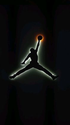 the silhouette of a basketball player jumping in the air