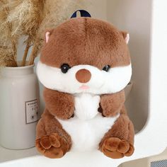 a brown and white stuffed animal sitting on top of a shelf