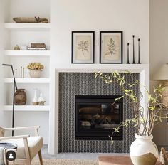 a living room filled with furniture and a fire place in front of a white wall