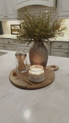 a kitchen counter top with a vase and candles on it