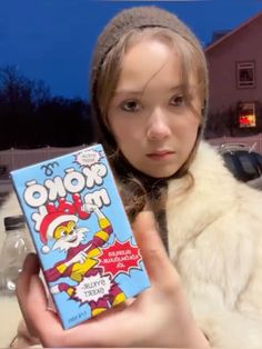 a young woman holding up a box of cereal