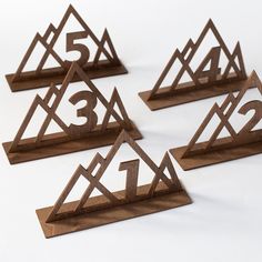 four wooden numbers are arranged in triangle shapes