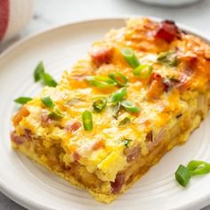 a slice of quiche on a white plate with green garnish and a fork