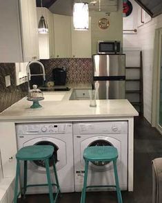 two stools are in front of the washer and dryer