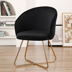 a black chair sitting on top of a hard wood floor next to a book shelf