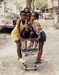 three young children are sitting in a shopping cart