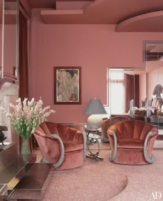 an elegant living room with pink walls and furniture in the center, along with a large mirror on the wall