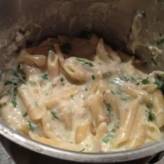 a pot filled with pasta and sauce on top of a table