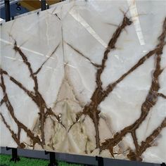 a large marble slab with brown branches on it's sides and green grass in the foreground