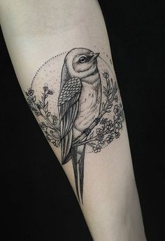 a bird sitting on top of a tree branch with leaves and flowers around its neck