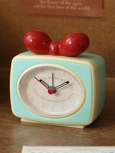 an alarm clock sitting on top of a wooden table