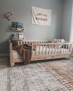 a baby's room with a crib, book shelf and rug